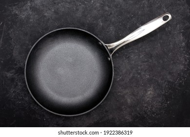 Empty Frying Pan, Top View. Cast Iron Fry Pan on Black Background. New And Clean Frying Pan On Black Table Overhead View.
