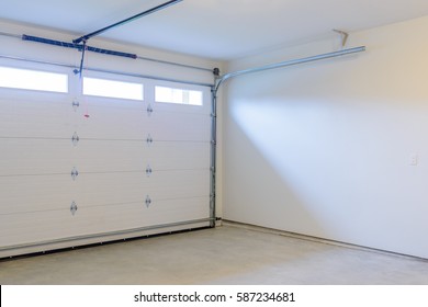 An Empty Garage With Door And Windows.