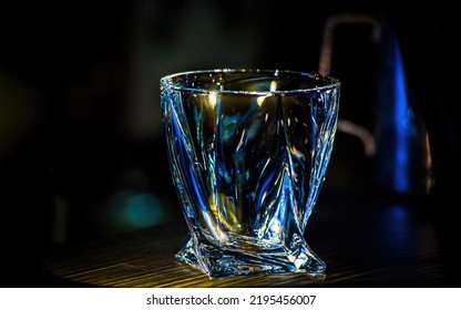 An Empty Glass Beaker Glows On A Dark Background.