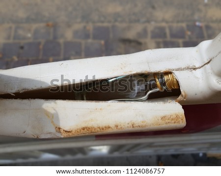 Empty glass bottle of alcohol was hidden in plastic fence. Concept photo Stock photo © 