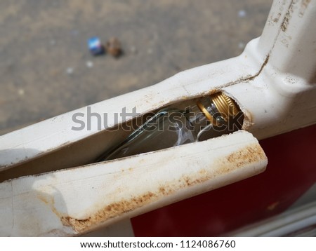 Empty glass bottle of alcohol was hidden in plastic fence. Concept photo Stock photo © 