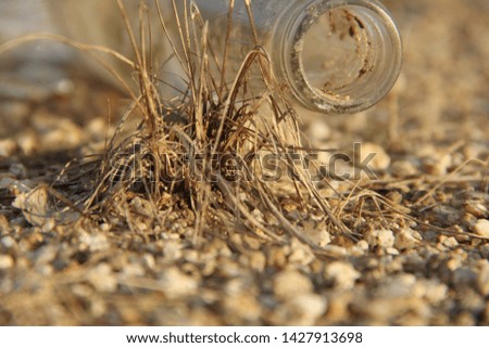 empty glass bottle on sand floor