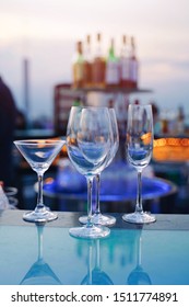 Empty Glass Of Cocktail And Champagne On Counter Bar Of Bartender In Luxury Rooftop 