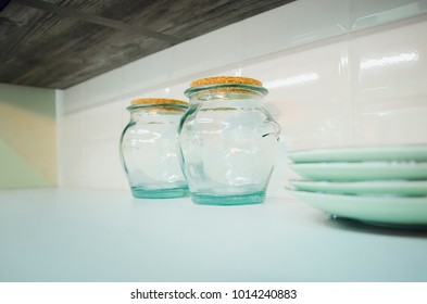 Empty glass containers on the kitchen shelf.