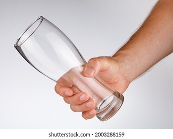 Empty glass in his hand on a white background