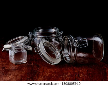 Empty glass jars with open lids are held in place with a metal wire.