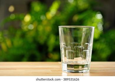 Empty Glass On Table With Green Garden Background