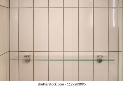 Empty Glass Shelf On Shower Wall With Rectangle White Tiles