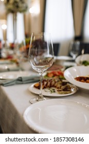 Empty Glasses Set In Restaurant. Wedding, Decor, Celebration, Holiday Concept - Romantic Table Setting With White Tablecloth, Plates, Crystal Glasses