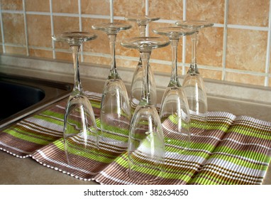 Empty glasses standing upside down on a towel.
