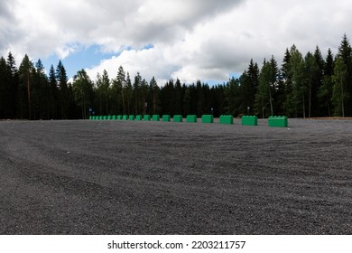 Empty Gravel Parking Lot With A Coniferous Forest In The Background
