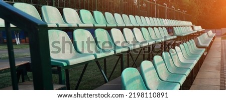Empty green colored plastic seat rows on stadium tribune. Sport and recreation and leisure concept.