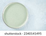 An empty green plate, overhead flat lay shot on a slate background, with copy space