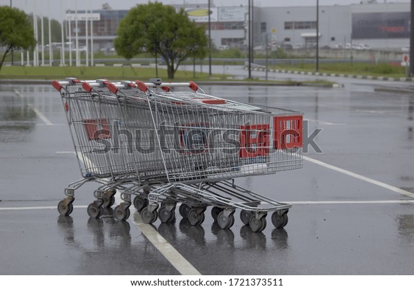empty grocery basket from the\
supermarket and its reflection in the rain in the Parking\
lot
