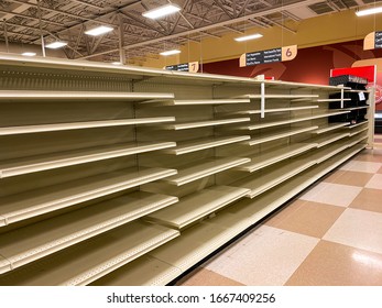 Empty Grocery Store Aisle With No Products Available On Shelves After Sell Out
