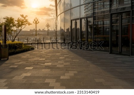 empty ground floor outside of  modern office building  exterior during sunrise.