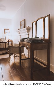 Empty Guest Room In A Boutique Hotel, Shabby Chic Style. Freshly Laundered Towels Stacked On Wooden Vintage Dressing Table