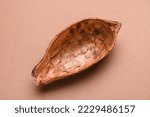 Empty half of cocoa pods shell on brown background