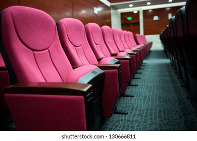Empty hall for presentation with red armchairs.