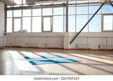 empty hall without people in the morning with sunlight, two yoga mats lie on the floor in the sports room for dancing - Powered by Shutterstock