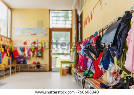 Empty hallway in the school, backpacks and bags on hooks, bright recreation room