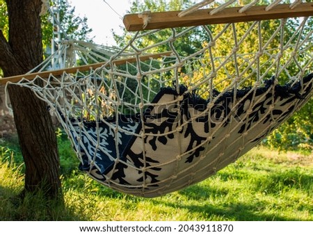 An empty hammock in a beautiful garden.