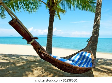 Empty hammock between palms trees at sandy beach