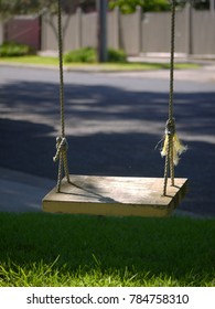 An Empty Handmade Wood Rope Swing Hanging On Tree On A Quiet Residential Suburban Street. Melbourne VIC Australia.