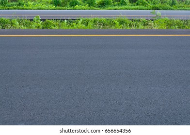Empty highway with dividing line, roadside and green grass, abstract transportation background,asphalt road new construction