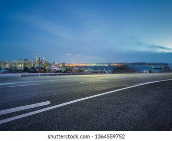 Empty Highway Road With Seattle Skyline Background At Night.