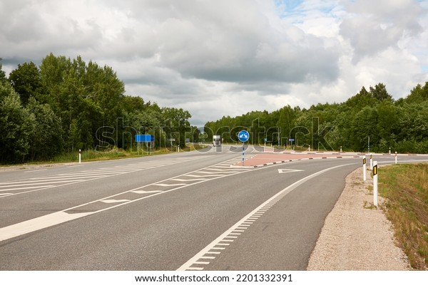Empty highway\
through the forest on a sunny day. Asphalt road surface marking.\
Estonia, Europe. Transportation, traffic law, wanderlust, remote\
places, summer vacations\
concepts