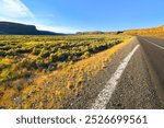 An empty highway through the high desert of the American Northwest near the city of Spokane, Washington and the Wenatchee Valley of Eastern Washington State.