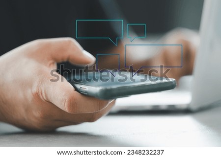 Empty hologram speech bubbles or text messages pop up from the cell phone screen on hand man. Texting, group chat concept. Customer service help desk with live support chatbot.