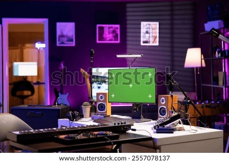 Empty home studio with computer running greenscreen display, audio equipment and mixing instruments used for recording tunes. Music production and acoustics gear in modern space.