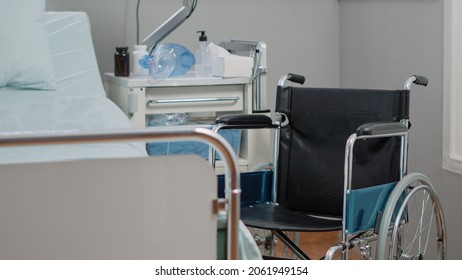 Empty Hospital Ward For Healthcare And Medical Recovery. Nobody In Intensive Care Space With Wheelchair, IV Drip Bag And Heart Rate Monitor. Emergency Room With Oxygen Tube And Medicine