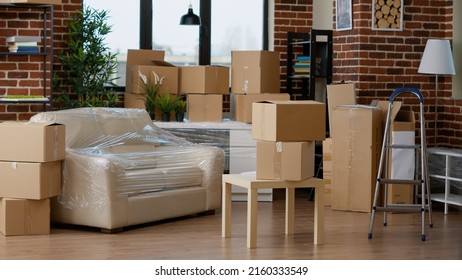 Empty Household Space With Cardboard Boxes Used For Relocation, Moving Home Furniture In Carton Containers And Storage Equipment. No People In New Apartment Flat To Movae Into.