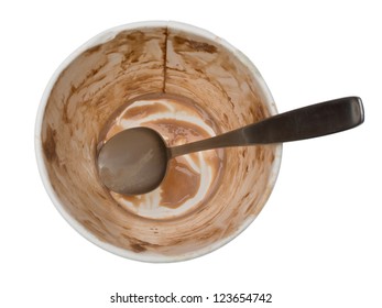 Empty ice cream container. The dirty spoon and the paper tub smeared with chocolate are all that's left of this pint of ice cream. Isolated on a white background