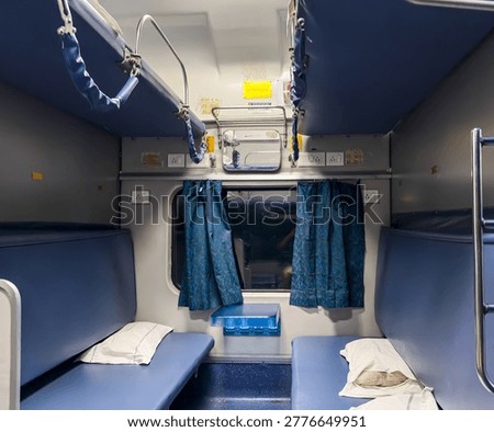 empty indian train 3ac sleeper cabin with berths pillows and window at night