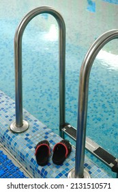 Empty Indoors Public Swimming Pool For Kids. Sports Balls. Children Center, Pool With Children Equipment. Flip Flops Near Side