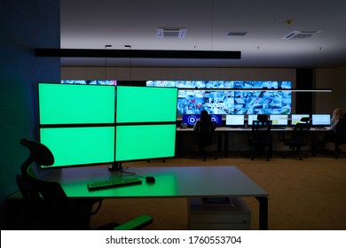 Empty Interior Of Big Modern Security System Control Room With Blank Green Screens, Workstation With Multiple Displays, Monitoring Room With At Security Data Center  Empty Office, Desk, And Chairs At 