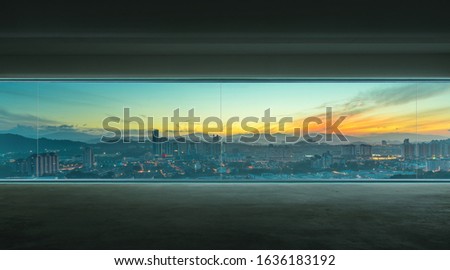 Empty interior with concrete floor and early morning cityscape view .