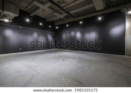 empty interior of large concrete room as warehouse or hangar with spotlights