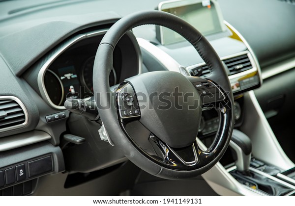 empty interior of modern premium\
car dark interior close-up steering wheel and driver\
seat