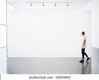 Empty interior with white, blank, canvas and young man. 
