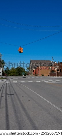 Empty intersection in a small town with traffic light on red
