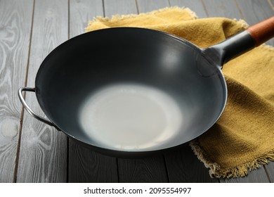 Empty Iron Wok And Napkin On Grey Wooden Table