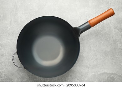 Empty iron wok on grey table, top view. Chinese cookware