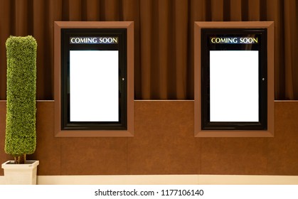 Empty Isolated Cinema Poster Panel On The Wall Of Theater Walkway, White Blank Mockup Movie Frame With Coming Soon Text For Insert Design