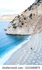 Empty Kaputas Beach At Kaş Antalya. Empty Beach Background With Sea, Sand, Sun Bed And Rocks. No People At Beach Concept.