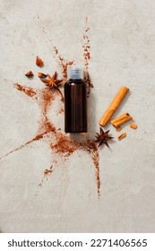 An empty label bottle arranged with star anise, cinnamon stick and cinnamon (Cinnamomum) powder. Cosmetic product mockup. Flat lay, overhead